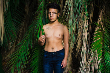 a transgender top surgery candidate standing in front of trees